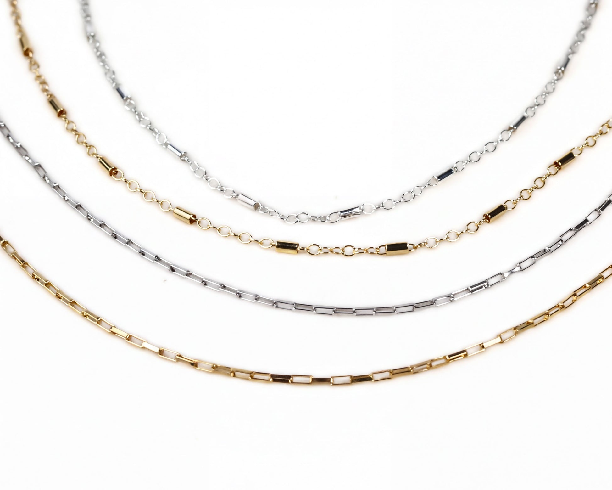 a collection of necklaces with various chain designs and colors, including silver, gold, and bronze.