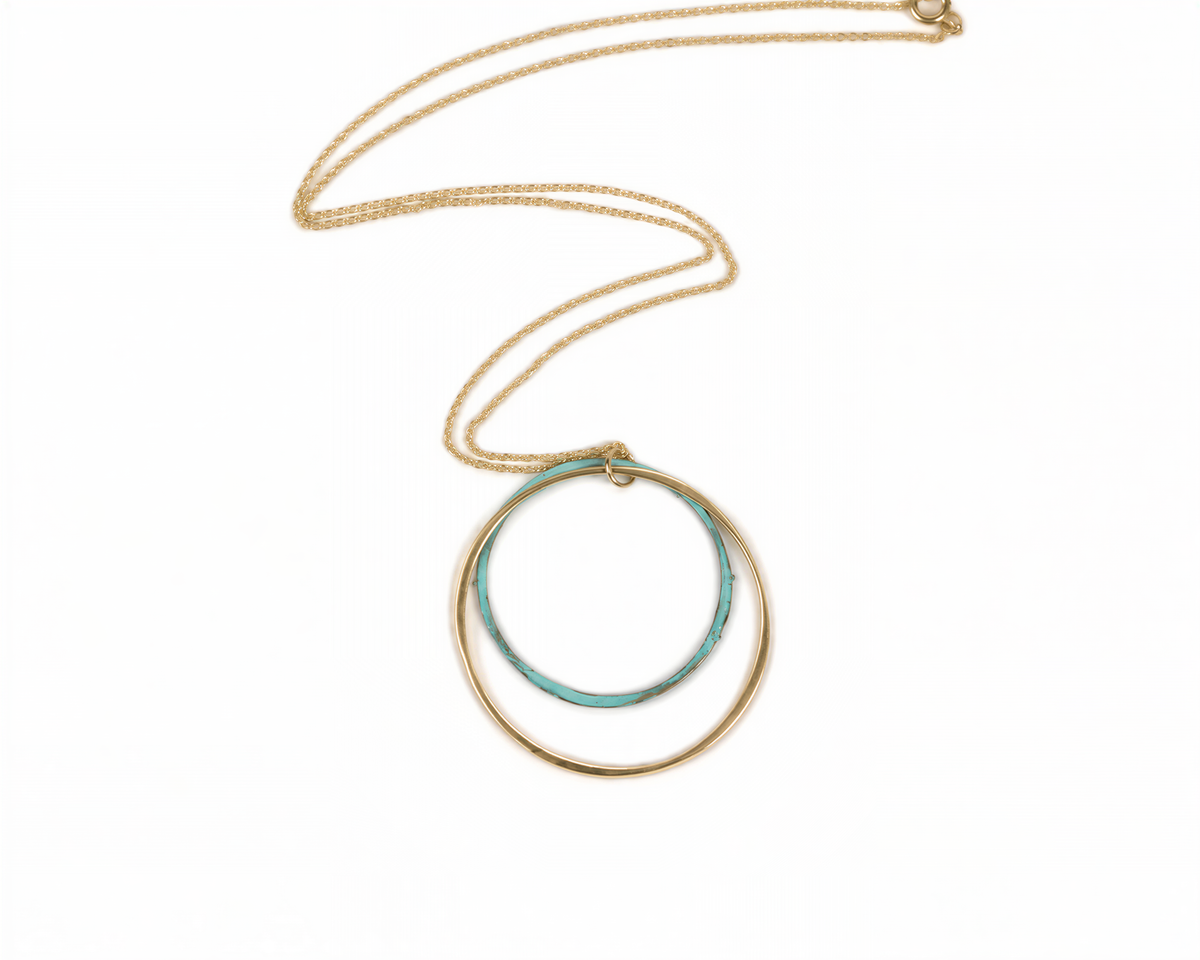 A gold necklace with a turquoise-colored circular pendant.