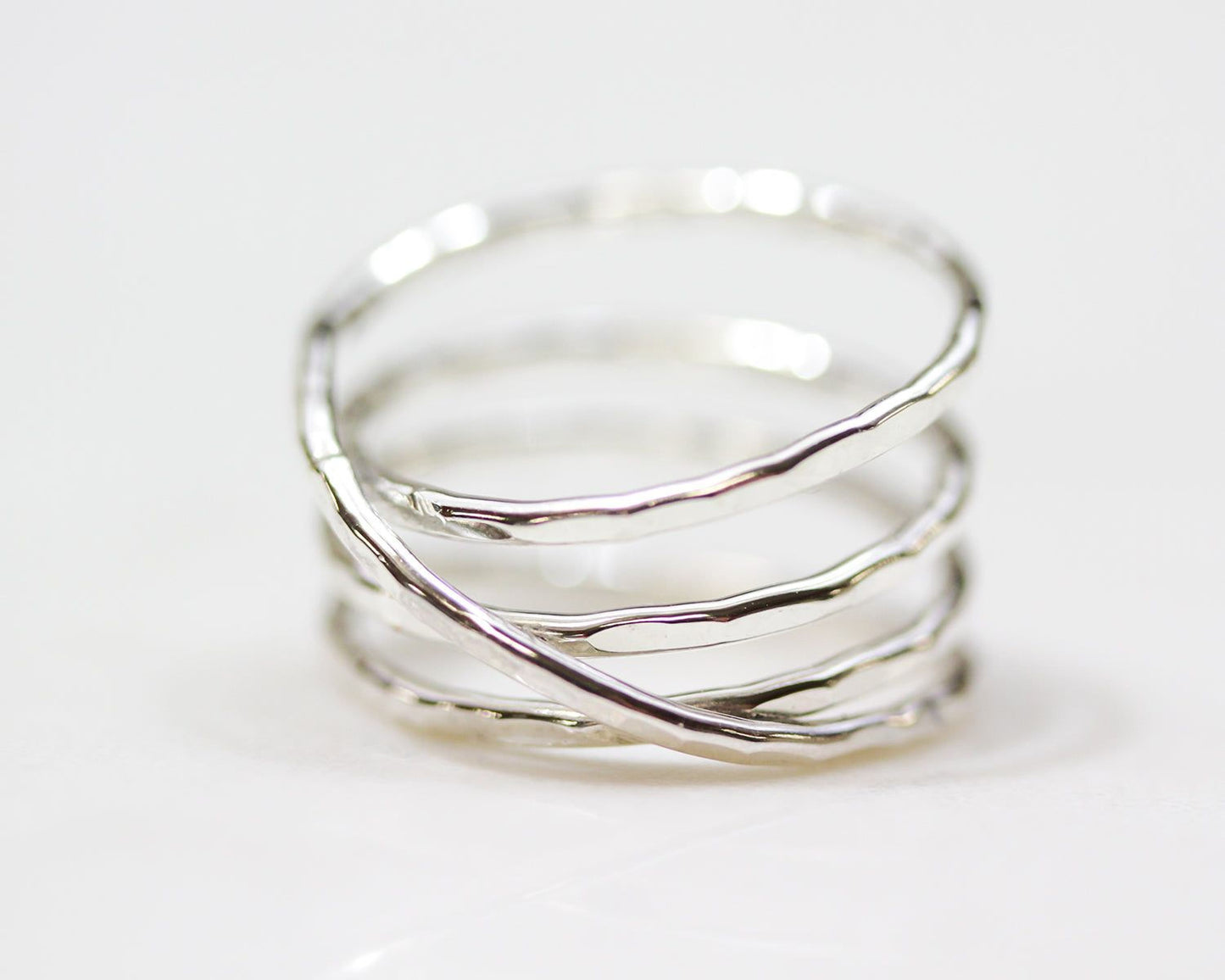 A silver ring with a unique twisted design, featuring multiple concentric bands.