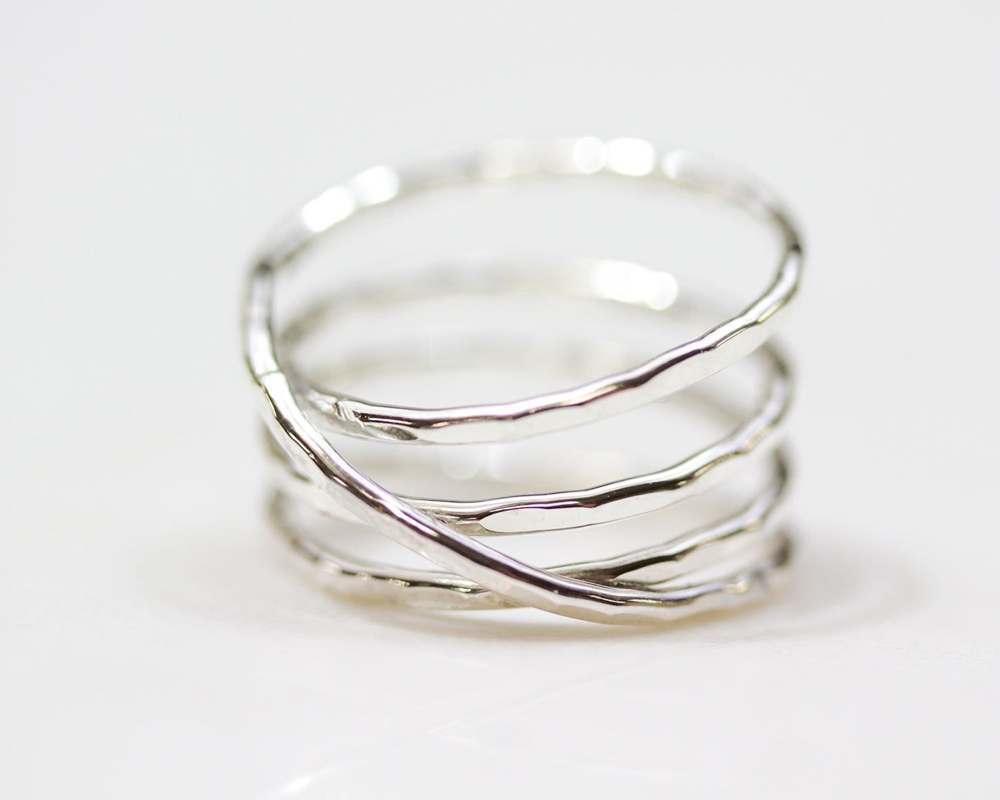 A silver ring with a unique twisted design, featuring multiple concentric bands.