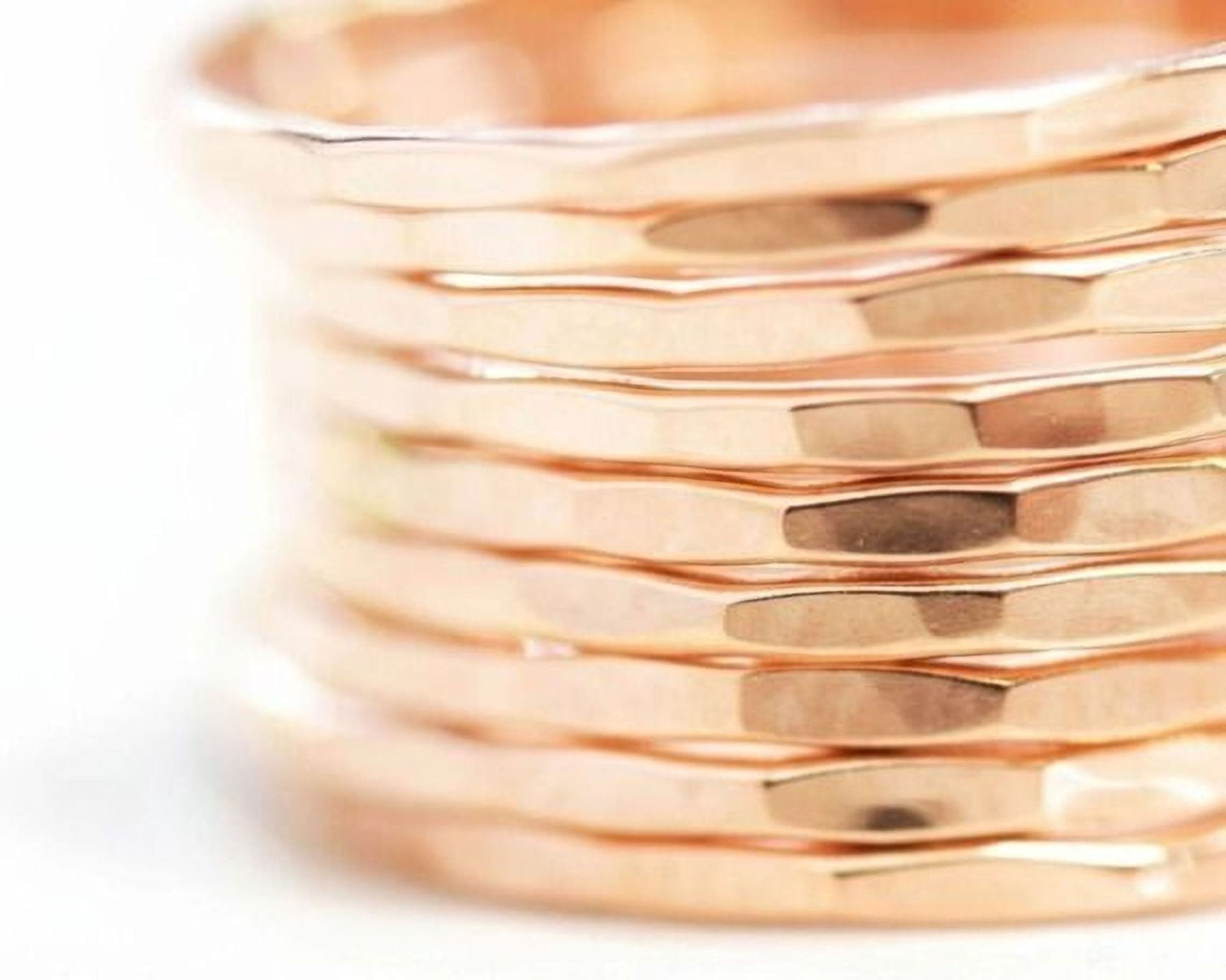 A close-up view of a stack of gold-colored rings, with the focus on the intricate details and textures of the rings.