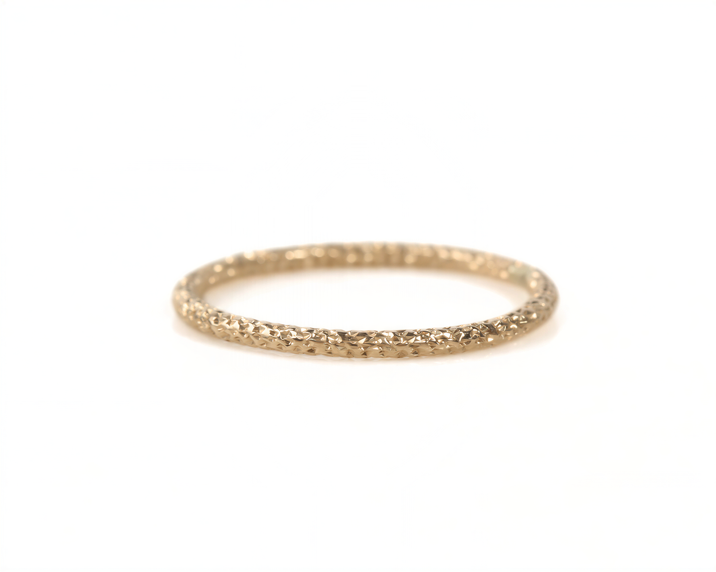 A gold ring with a textured band is shown against a white background.