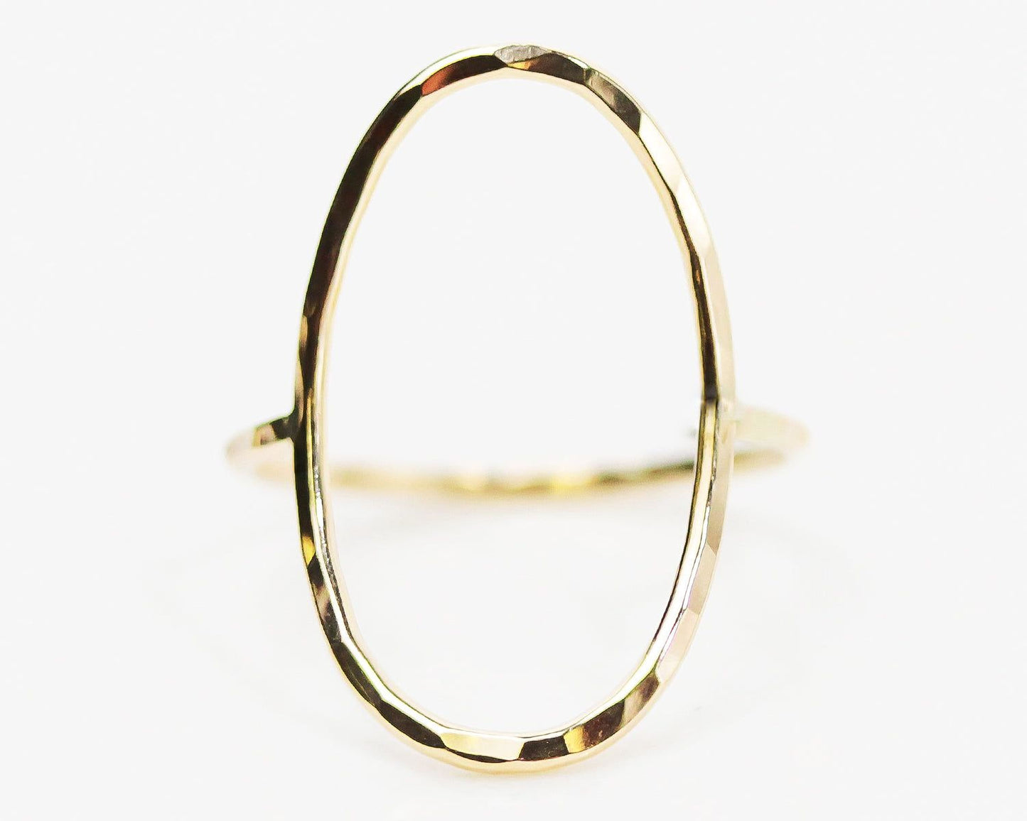 A gold ring with a unique oval shape.