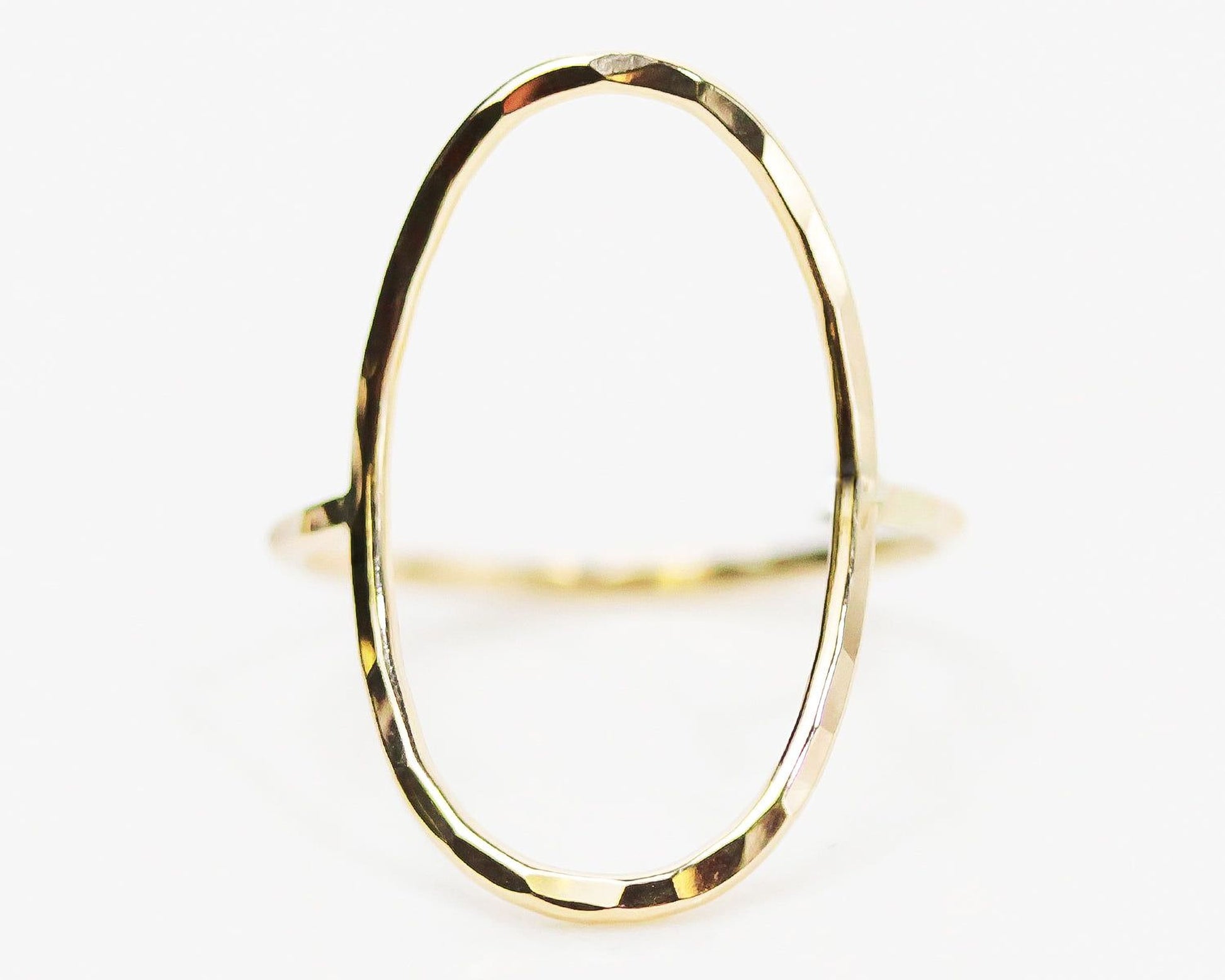 A gold ring with a unique oval shape.