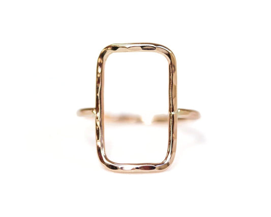 A gold ring with a rectangular cutout in the center.