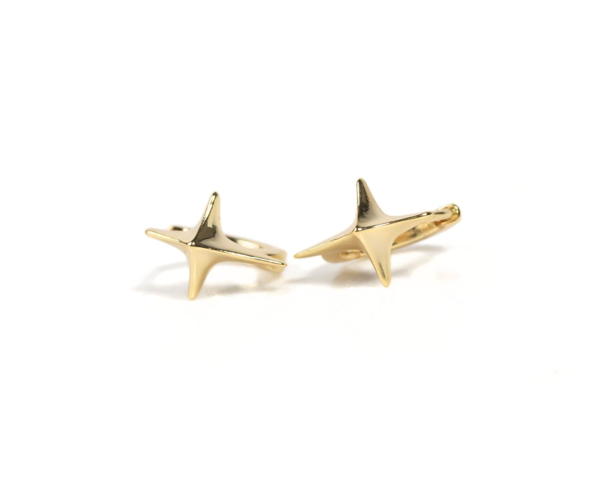 two gold star-shaped earrings with pointed tips.