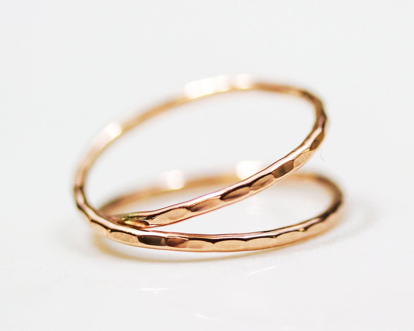 A pair of gold-colored rings with a textured surface, placed on a white background.
