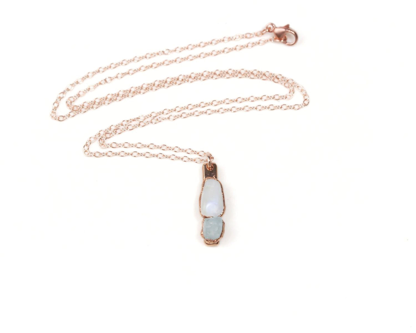 A delicate necklace with a pendant featuring two light blue stones.