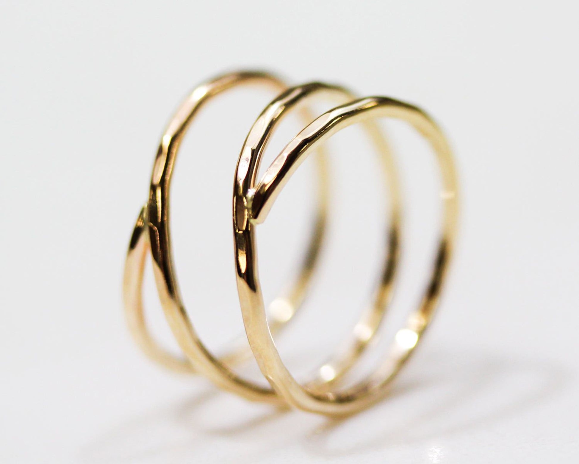 A close-up image of a gold ring with a twisted design.