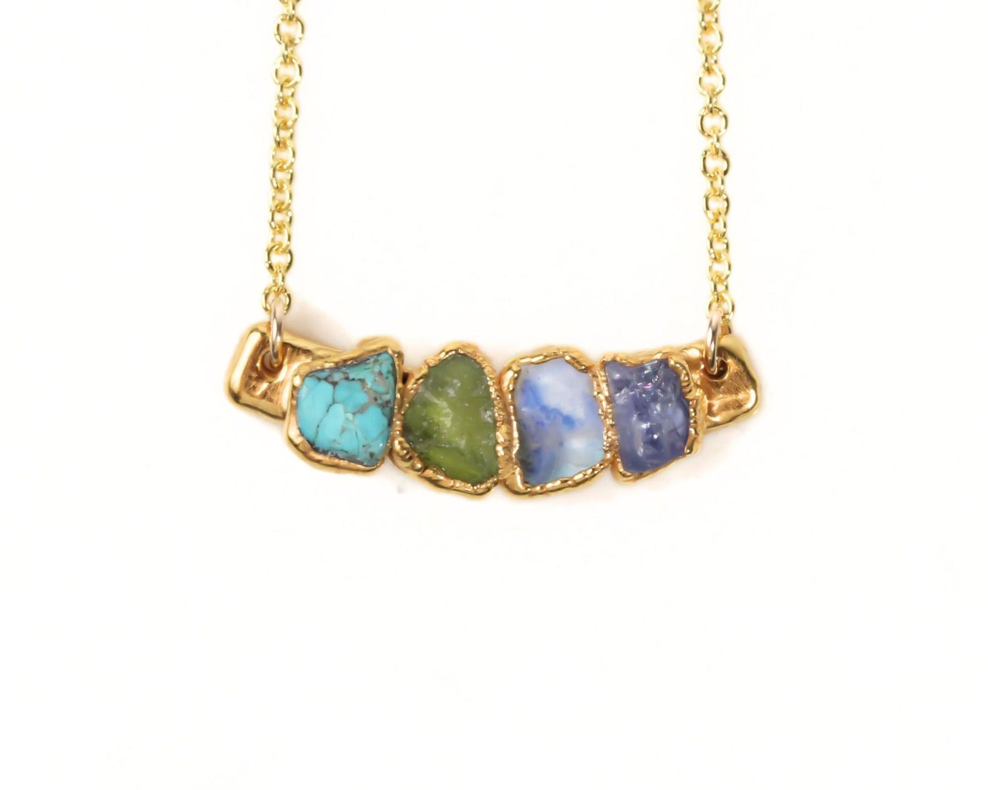 A gold necklace with a row of colorful gemstones on it.