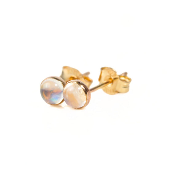 A pair of gold earrings with small, round stones in the center.