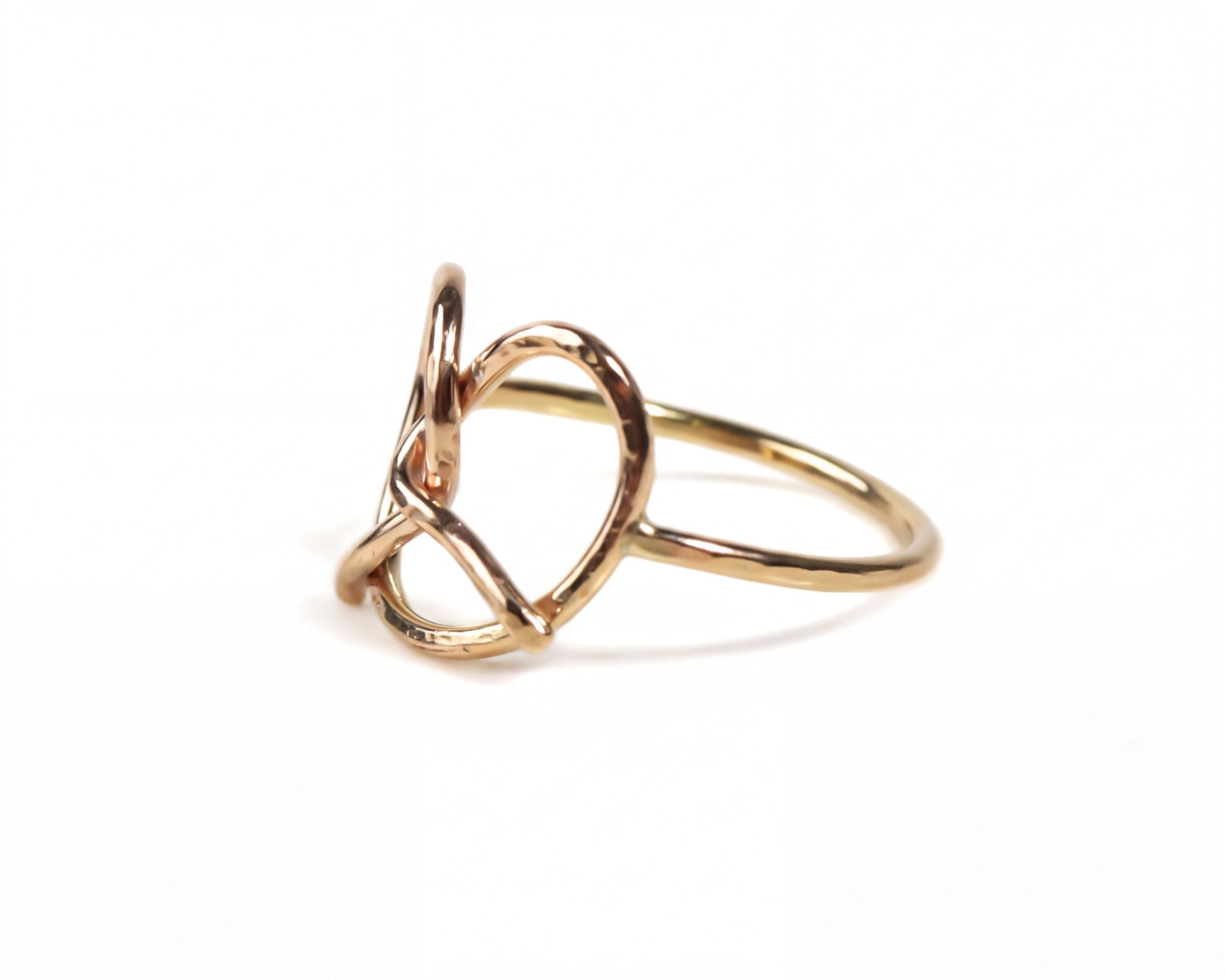 A gold ring with a twisted, heart-shaped design.