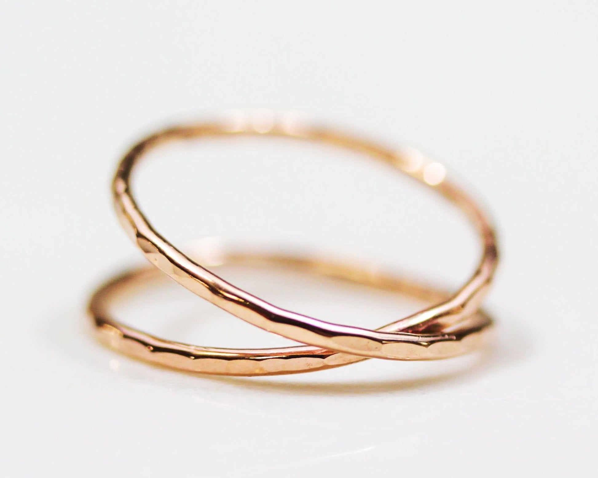 A close-up image of two overlapping gold rings on a white background.