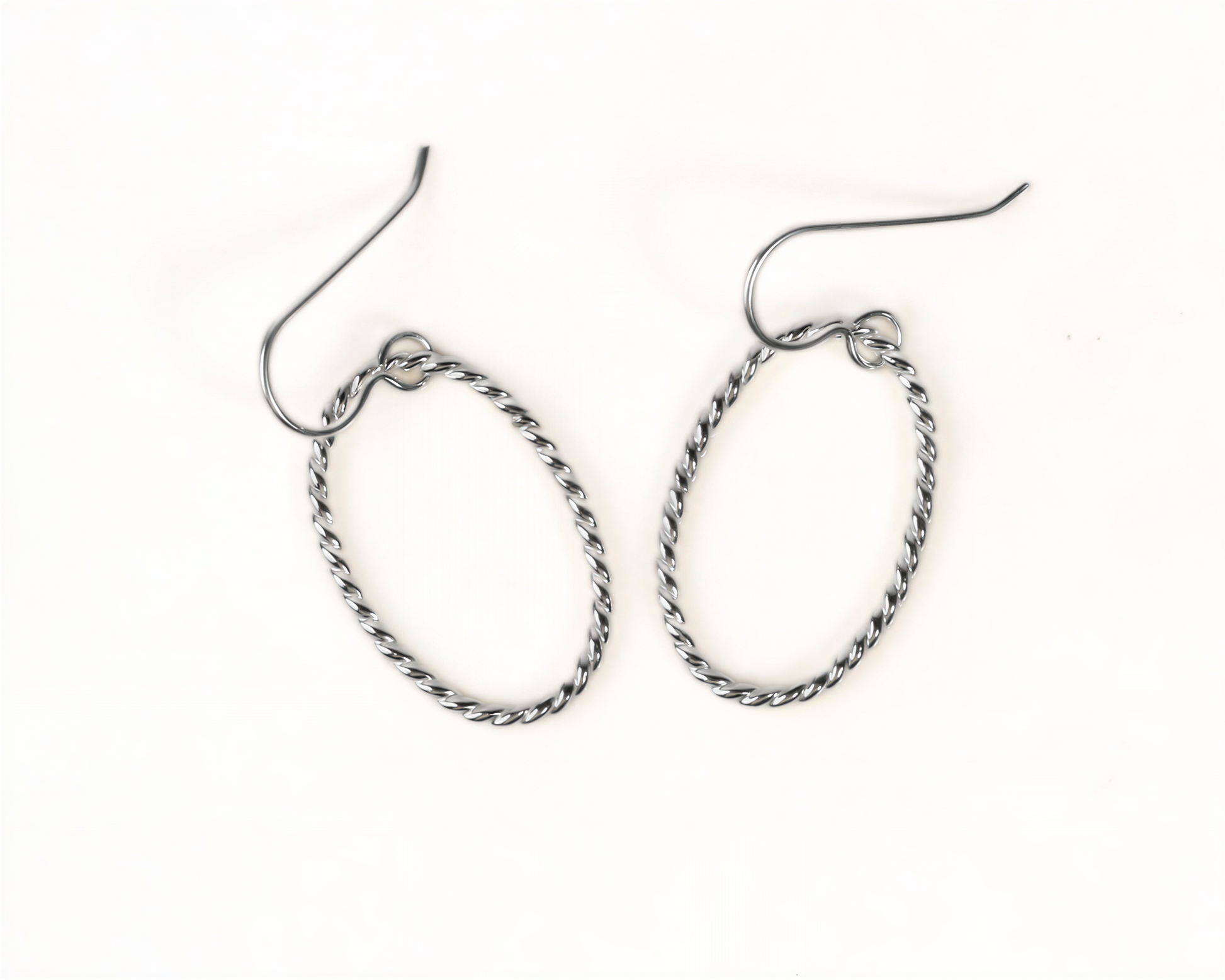 A pair of silver-colored metal earrings with twisted metal designs.