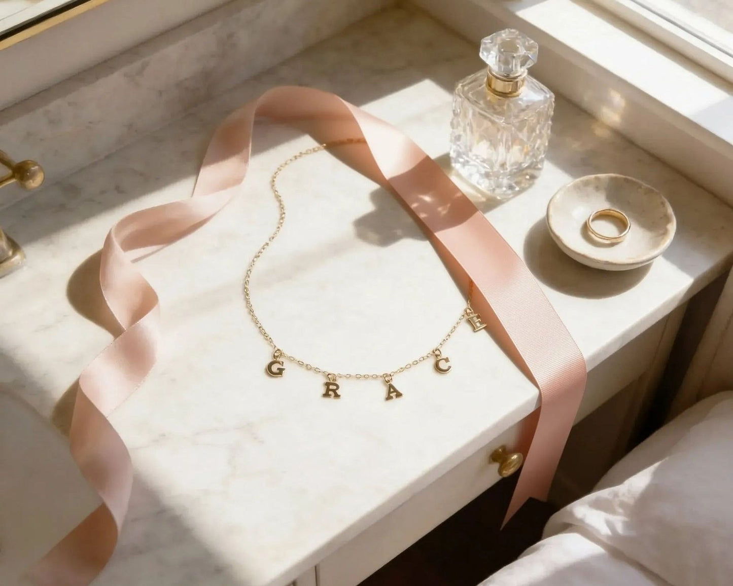 a vanity counter with a necklace, a perfume bottle, and a ring on it.