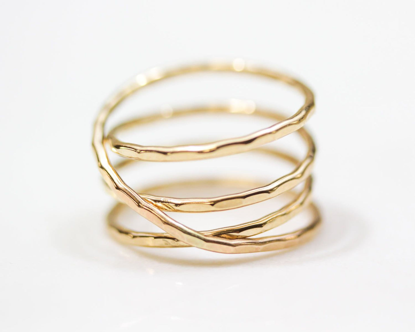 A close-up image of a gold ring with a twisted, coiled design.