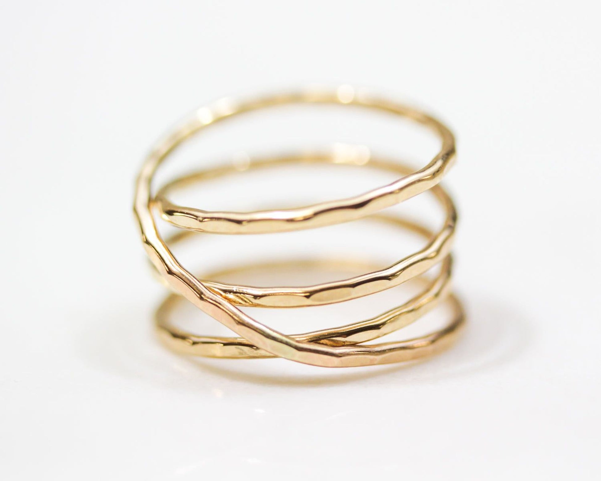 A close-up image of a gold ring with a twisted, coiled design.
