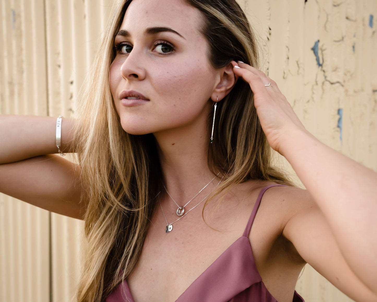 Model is wearing our birthstone pendulum earrings in sterling silver. All handcrafted in the highest quality materials, these earrings are paired with genuine emerald stones. Ear wires are sterling silver as well. Hand hammered and handmade.