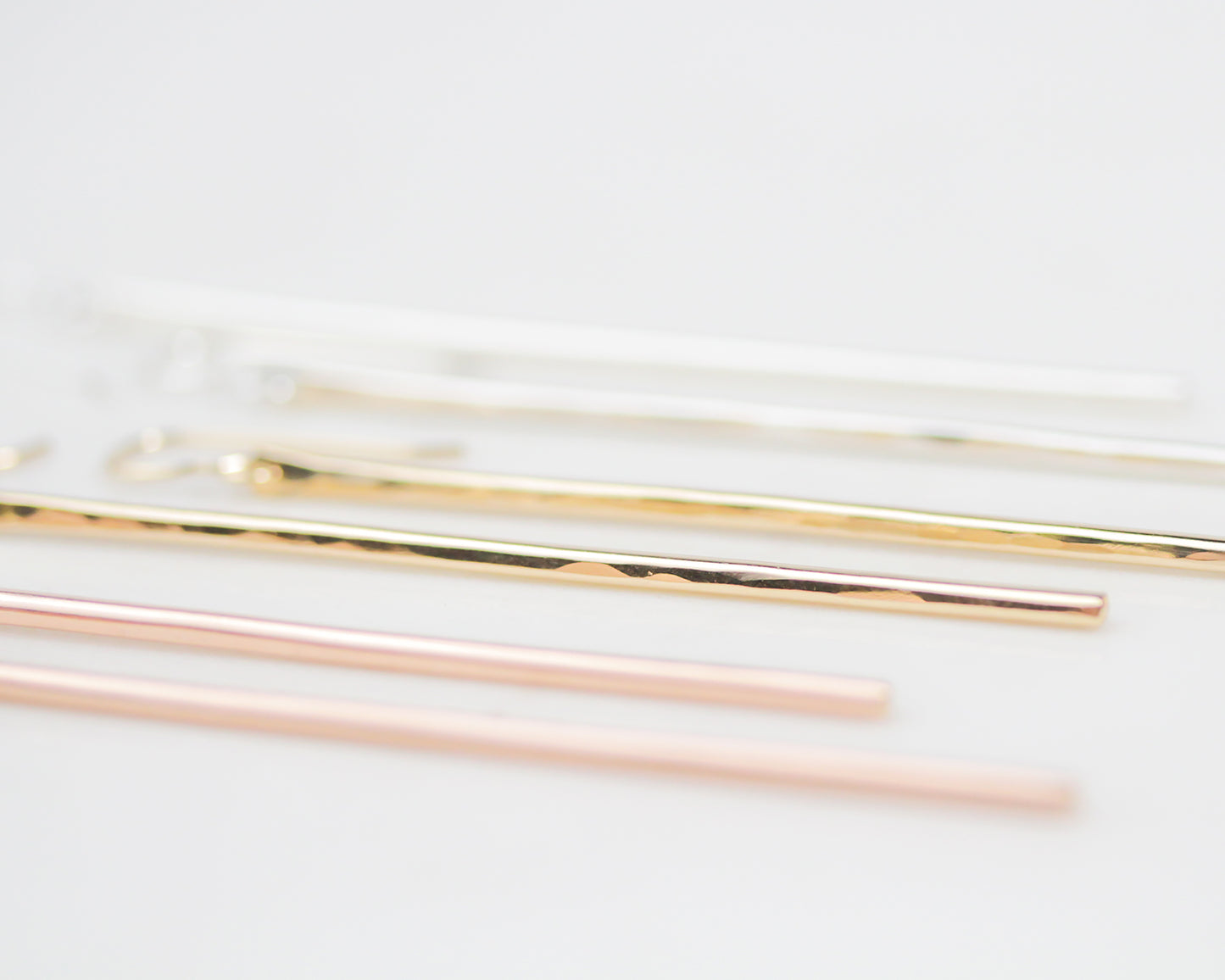 Image shows side view of the long, slender bar earrings showing the lovely hand hammered texture. High quality and fine metal will stand the test of time and not fade or tarnish. Can be worn in the water and daily.