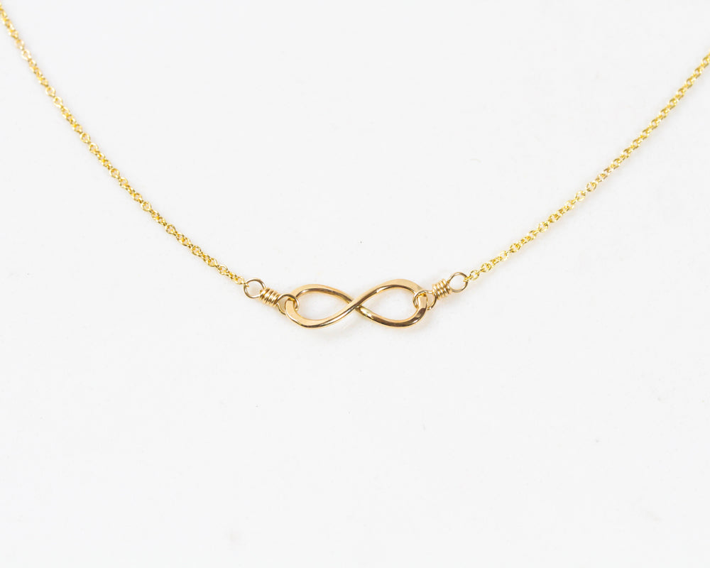 Image shows close up on our Infinity Necklace in 14 karat yellow gold filled. The Infinity symbol necklace is symbolic and steeped in meaning. A perfect Valentines gift or anniversary gift, it demonstrates the forever in your connection.