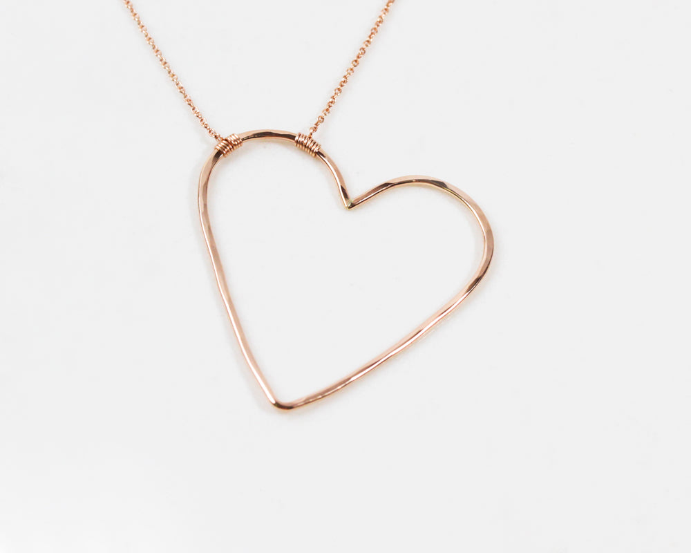 Image shows our 14 karat rose gold filled sweet heart necklace. The purposefully asymmetrical design is playful, fun and unique. Get prepared to sweep her off her feet with this beautifully handmade and expertly crafted design with elevated materials