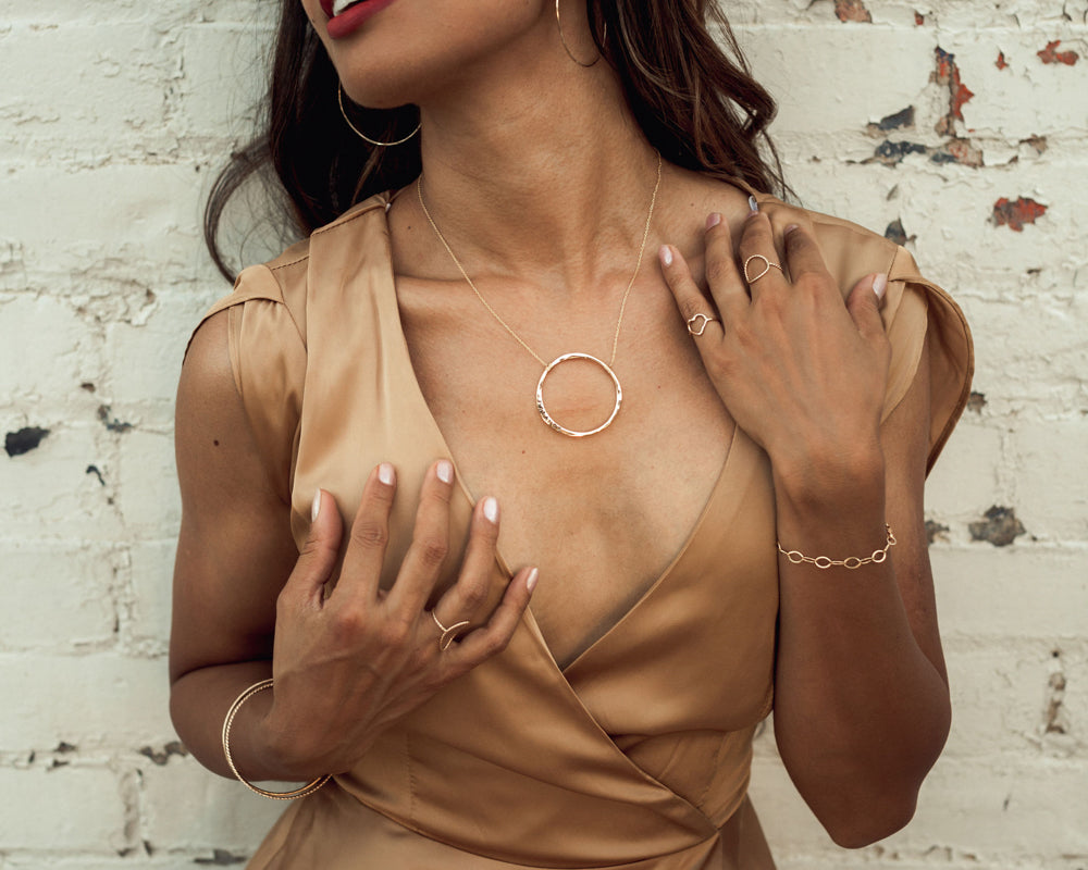 Model is wearing a single oval link 14 karat gold filled bracelet. It glints and gleams and catches the light beautifully. Each oval is linked together. Great layered or stand alone. Perfect gift for her or gift for self. High quality design.