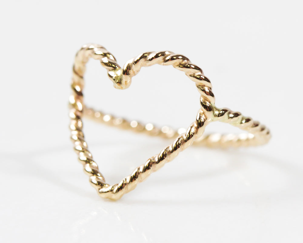 Close up image shows the side view of our 14 karat yellow gold filled open heart ring. The heart is delicately hand soldered to the band for a comfortable fit. Ring is offered in most sizes and in all three fine metal selects. Perfect love gift.