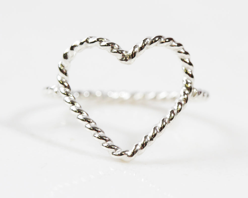 Image shows close up of our twisted open heart ring in sterling silver. The twisted wire adds interest and beautiful texture to this otherwise simple ring. Make a statement while wearing this beautifully detailed ring. Love is the answer. Great gift!